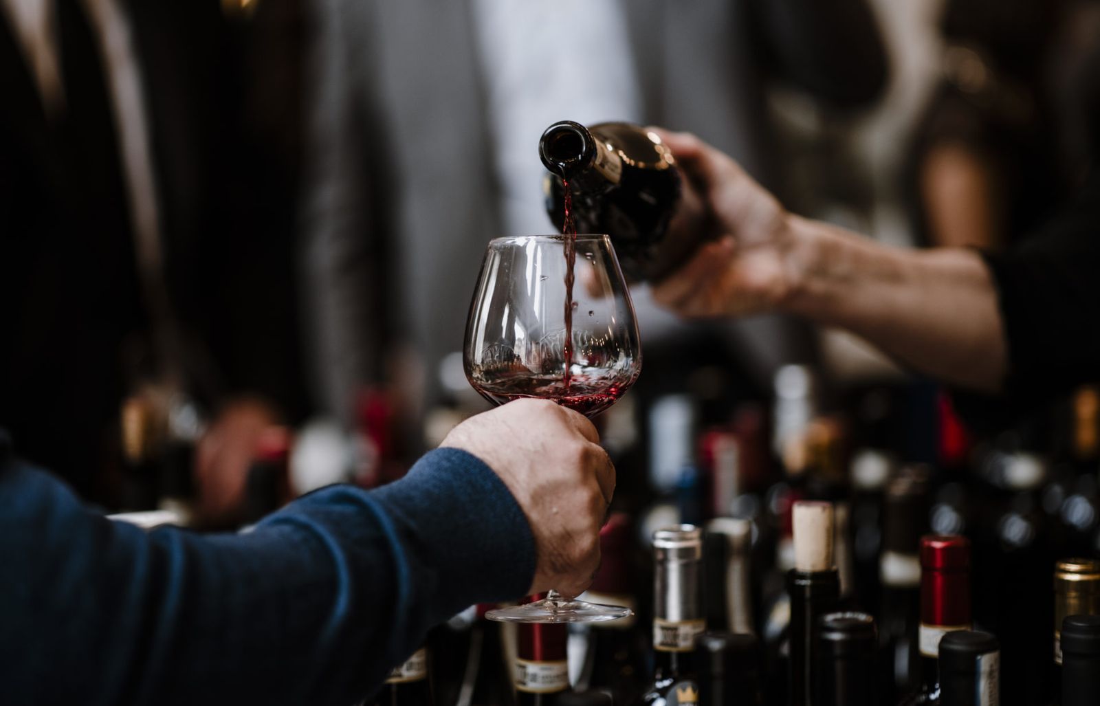 Vino rosso versato nel calice al banco d’assaggio